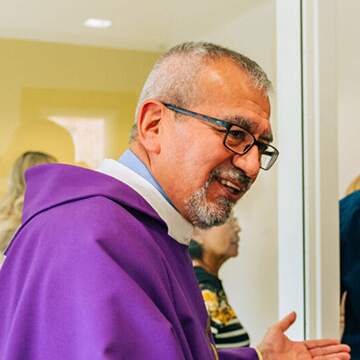 Padre Carlos smiling.